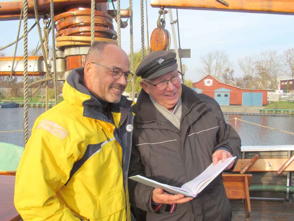 Die beiden Schiffskapitäne mit dem Logbuch in der Hand (Foto: hjs)